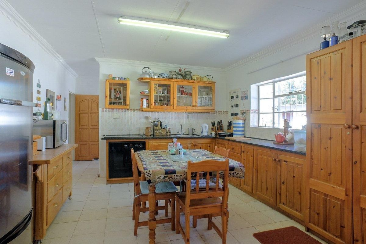A functional kitchen featuring wooden cabinetry, tiled flooring, and a built-in oven, offering a traditional farmhouse aesthetic with ample storage space.