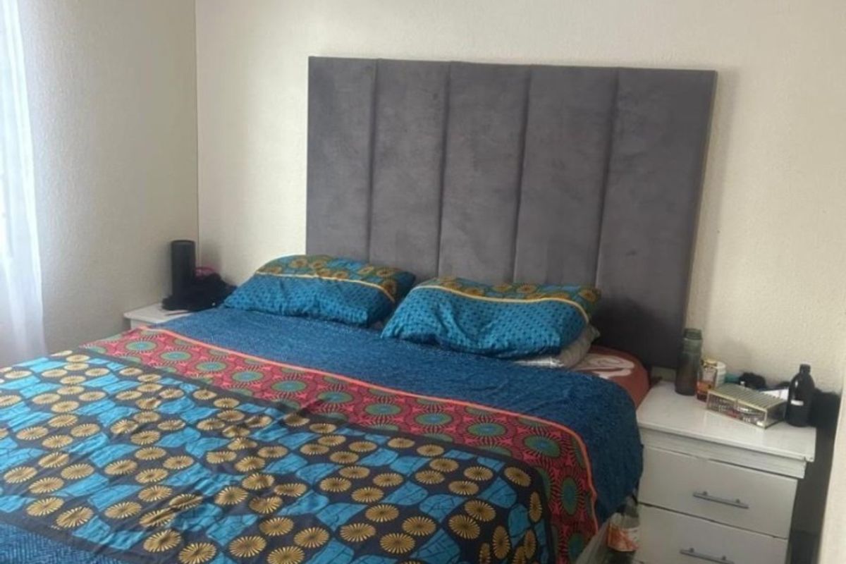 A bedroom featuring tiled flooring and a neutral wall finish, providing a functional and comfortable sleeping space.