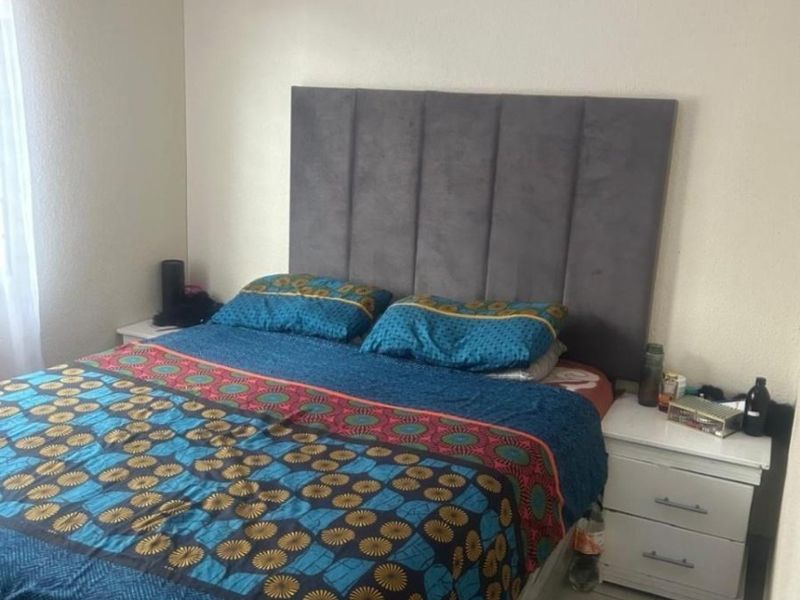 A bedroom featuring tiled flooring and a neutral wall finish, providing a functional and comfortable sleeping space.