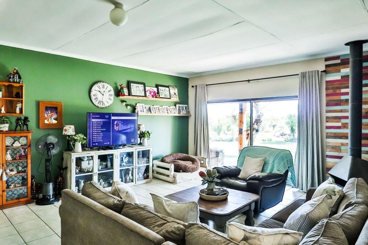Spacious living room featuring a built-in wood-burning fireplace, tiled flooring, and large sliding doors providing natural light and access to the outdoor area.