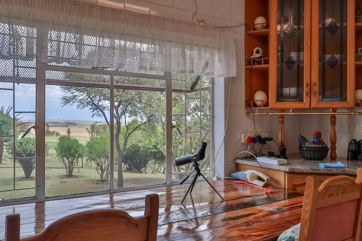 Kitchen area featuring wooden cabinetry and a large window with expansive views of the surrounding farm landscape.