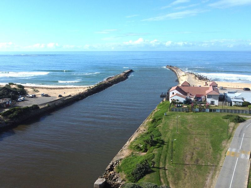 Aerial view of the coastal property location, showcasing the river mouth, beach access, and surrounding landscape.