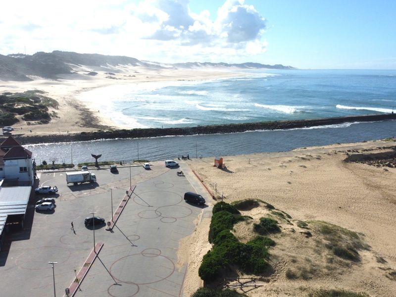 Aerial view of the coastal property, showcasing its proximity to the beach, river mouth, and surrounding natural landscape.