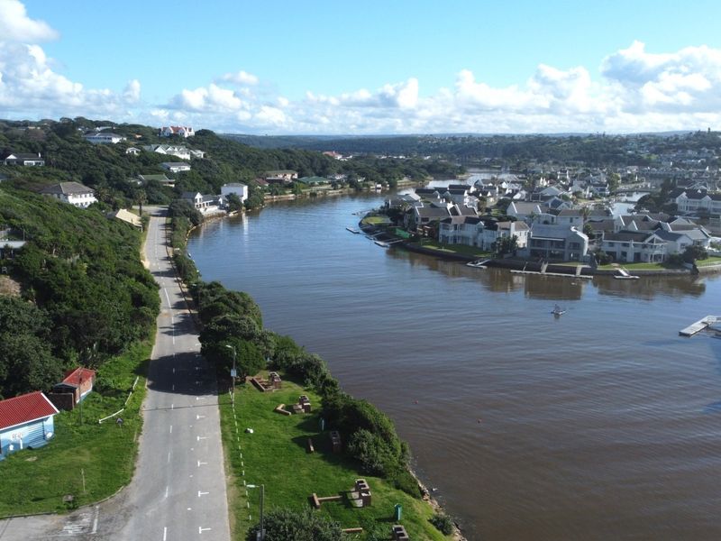 An aerial view of the coastal estate, showcasing the river, surrounding landscape, and residential properties.