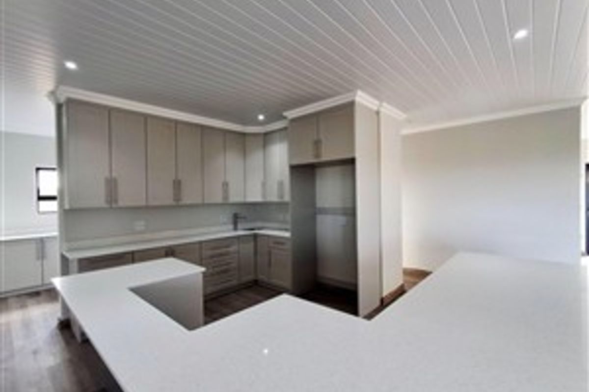 Modern kitchen featuring light-toned cabinetry, stone countertops, a U-shaped breakfast bar, and a tongue-and-groove ceiling with recessed lighting.
