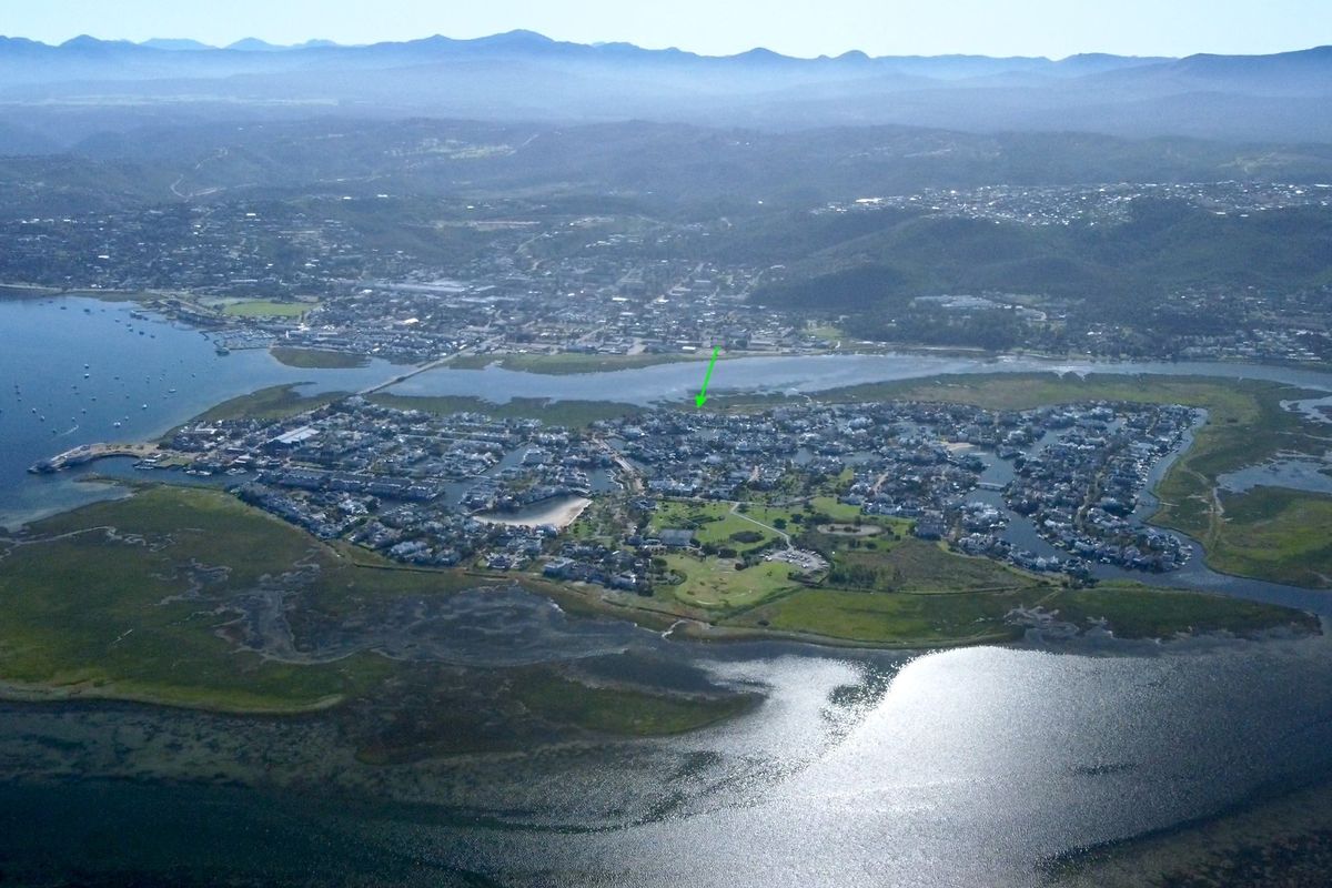 An aerial view of the coastal estate and surrounding lagoon landscape, highlighting the property's prime location within the residential development.