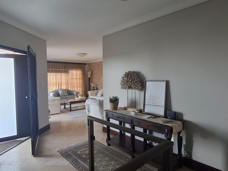 An inviting entryway leading into a spacious living area with tiled flooring and neutral wall tones, providing a seamless flow throughout the home.