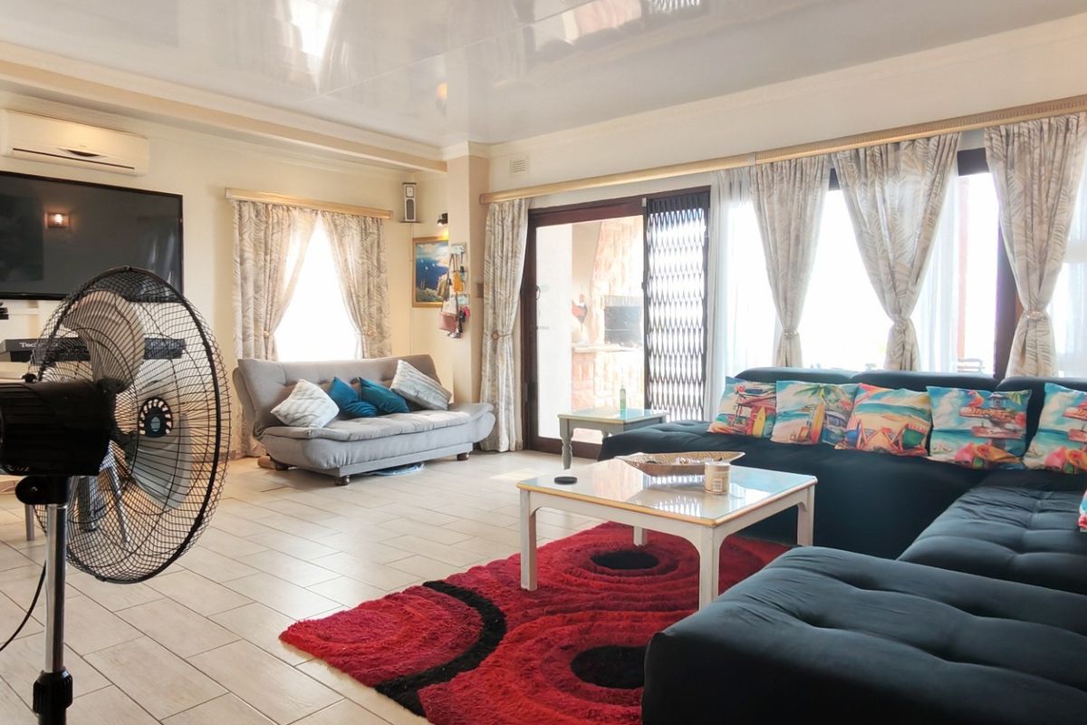 Spacious living room featuring tiled flooring, a split-system air conditioner, and large sliding glass doors providing access to the outdoor area.