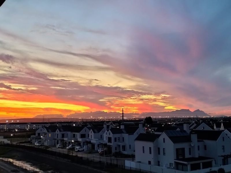 A scenic elevated view of the surrounding residential estate at sunset, captured from an apartment balcony.