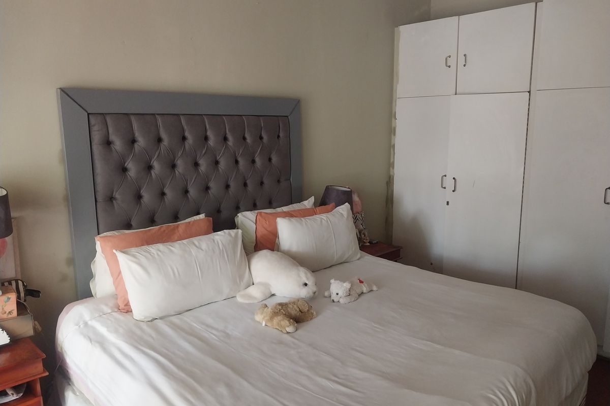 A bedroom featuring built-in white cabinetry and a tufted headboard, offering functional storage and a neutral base for interior design.