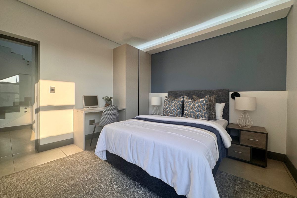 Modern bedroom featuring built-in cabinetry, recessed ceiling lighting, and a neutral color palette with a feature wall.