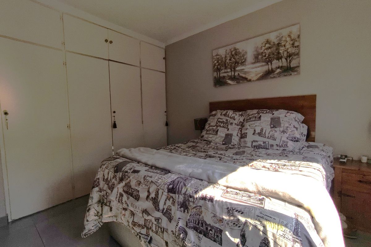 A bedroom featuring built-in floor-to-ceiling cupboards and tiled flooring, offering functional storage space within a standard residential layout.