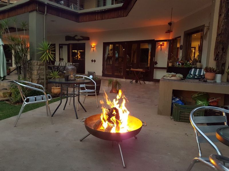 A spacious covered patio area featuring a built-in masonry counter and stone pillar accents, perfect for outdoor entertaining.