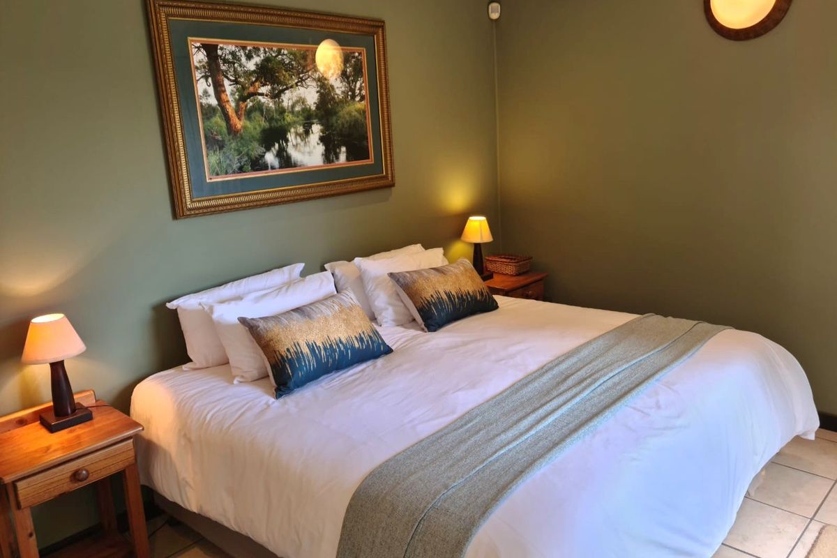 A comfortable bedroom featuring tiled flooring and wall-mounted lighting, providing a functional and well-maintained sleeping space.