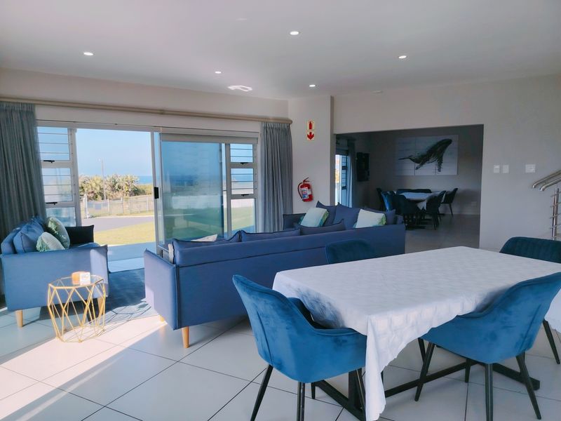 Spacious open-plan living and dining area featuring large sliding glass doors that provide seamless access to the outdoor space and natural light.