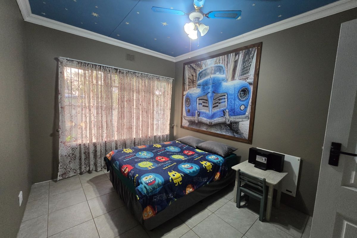 A bedroom featuring tiled flooring, a ceiling fan with integrated lighting, and a decorative star-patterned ceiling finish.