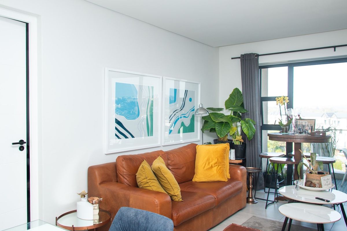 A bright and modern living room featuring large windows, neutral walls, and a contemporary door with black hardware.