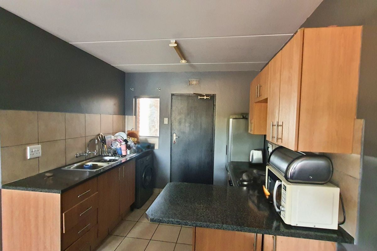 A functional kitchen featuring laminate cabinetry, granite countertops, a tiled backsplash, and integrated appliances, providing a practical workspace for daily cooking and preparation.