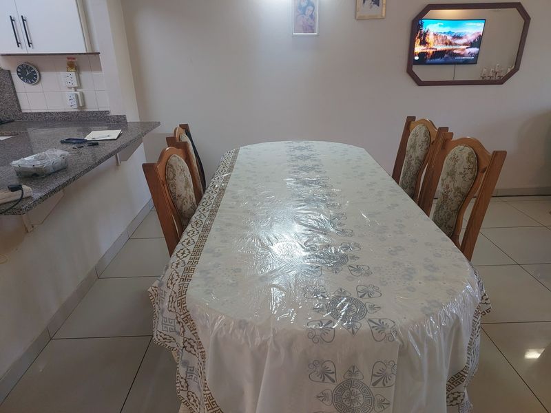 Open plan dining area featuring tiled flooring and a breakfast bar counter connecting to the kitchen space.