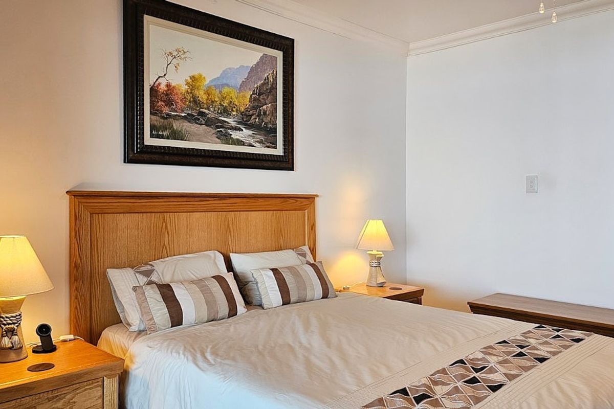 A well-maintained bedroom featuring crown molding and a neutral color palette, providing a comfortable and inviting space.