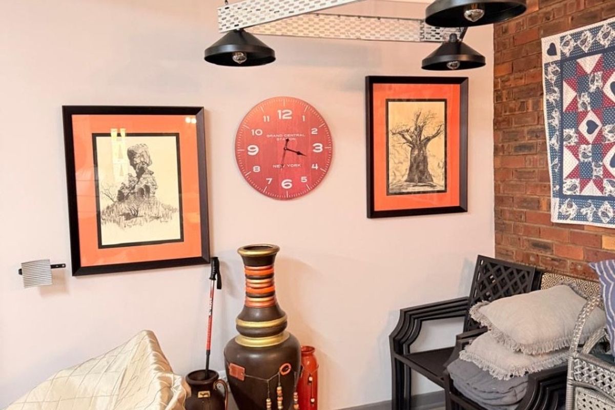 A living area featuring a rustic exposed brick feature wall, concrete flooring, and industrial-style pendant lighting.