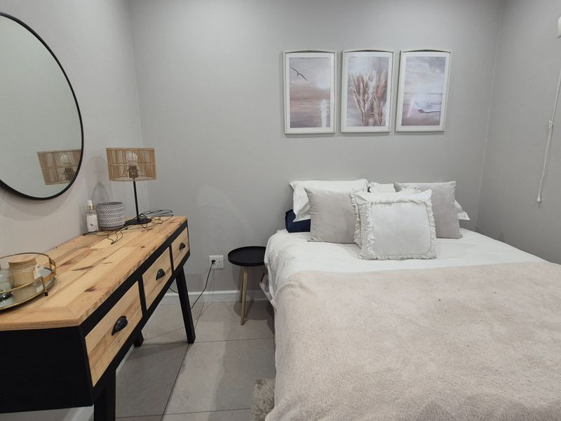 A well-maintained bedroom featuring neutral wall tones, tiled flooring, and a window, providing a clean and comfortable living space.