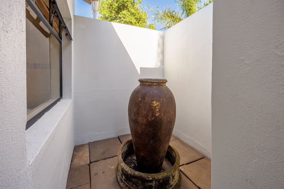 A private, enclosed courtyard area featuring paved flooring and a decorative water feature, providing a secluded outdoor space.