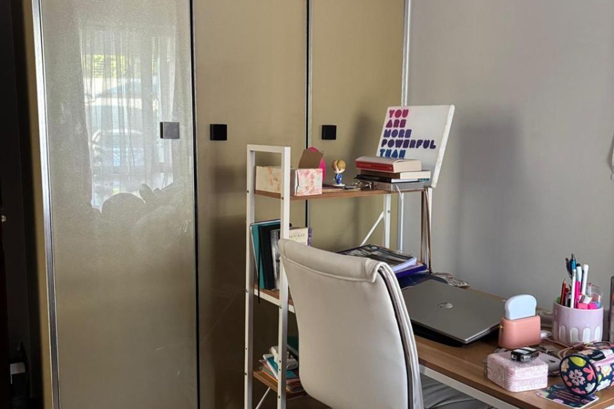 A bedroom featuring a modern built-in wardrobe with reflective panels and light-toned laminate flooring.