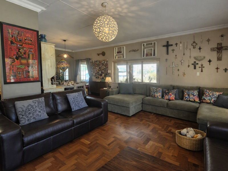 Spacious living room featuring classic parquet flooring and decorative cornice detailing, offering a warm and inviting atmosphere.