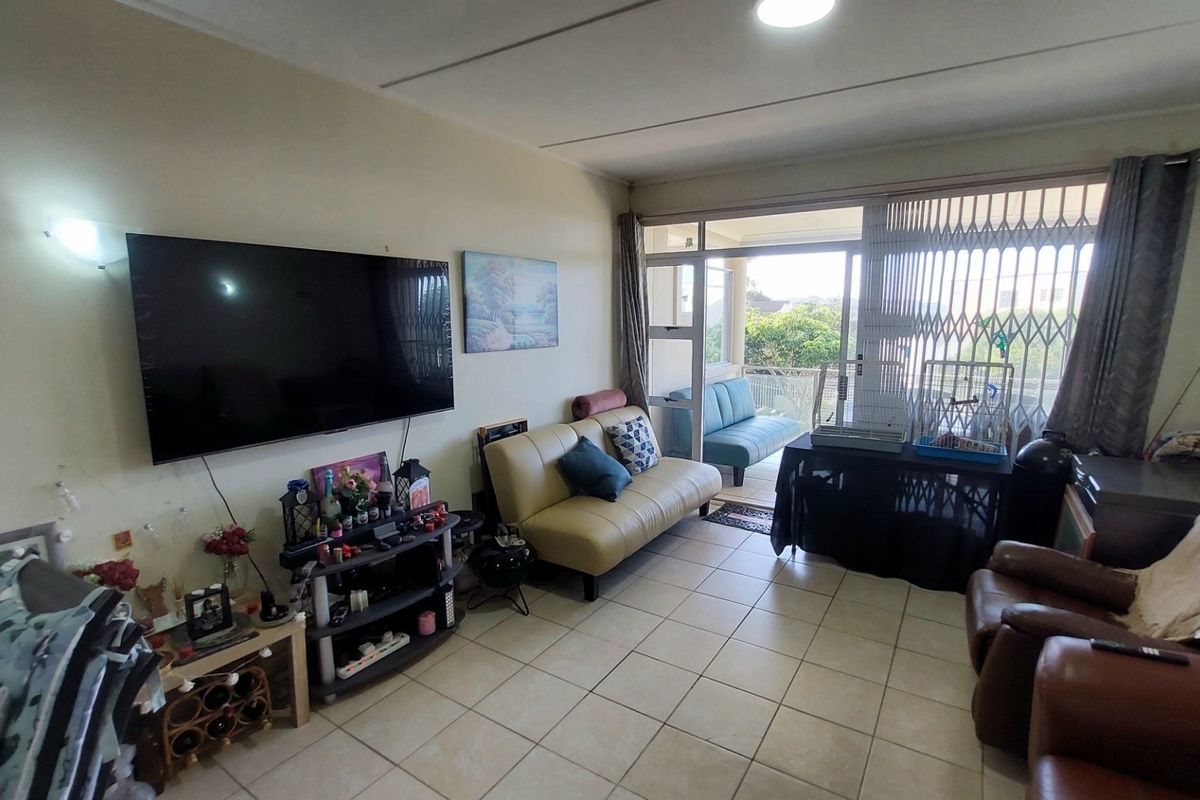 A living room featuring tiled flooring and a sliding door leading to an outdoor balcony area.