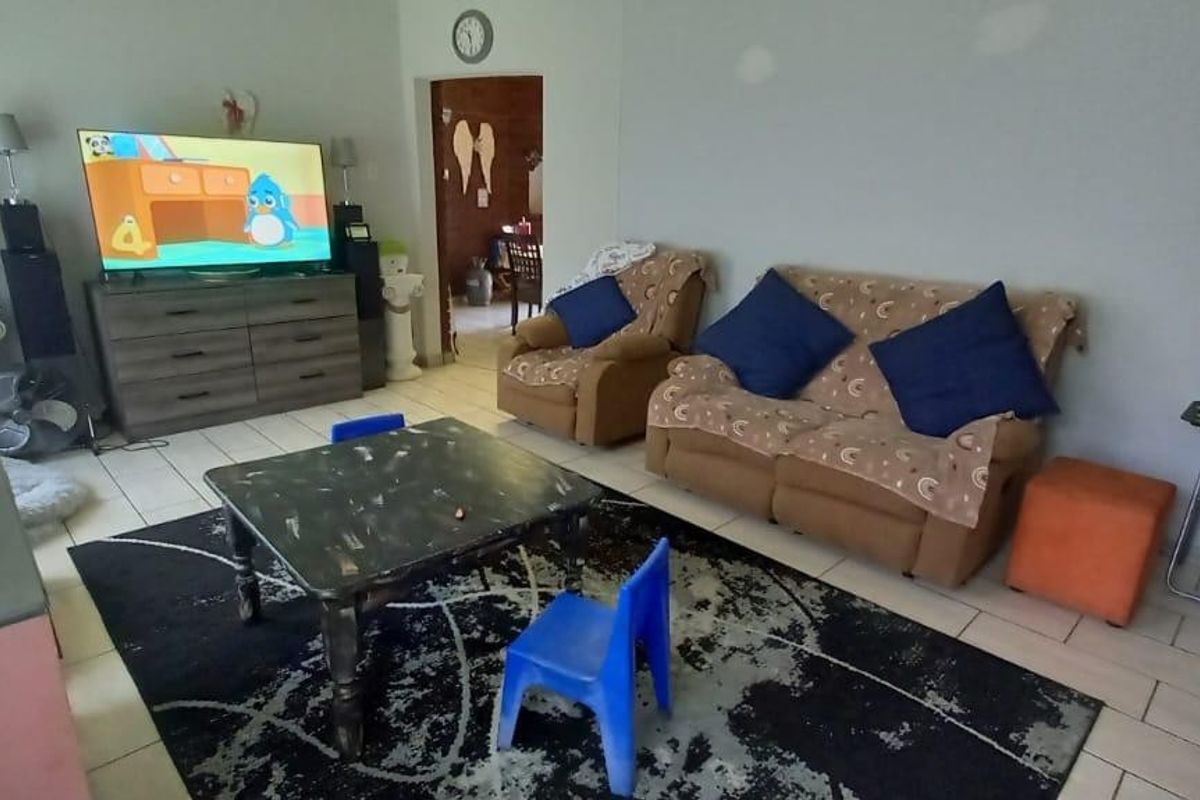 A functional living room space featuring tiled flooring and a neutral wall finish, providing a comfortable area for daily relaxation.