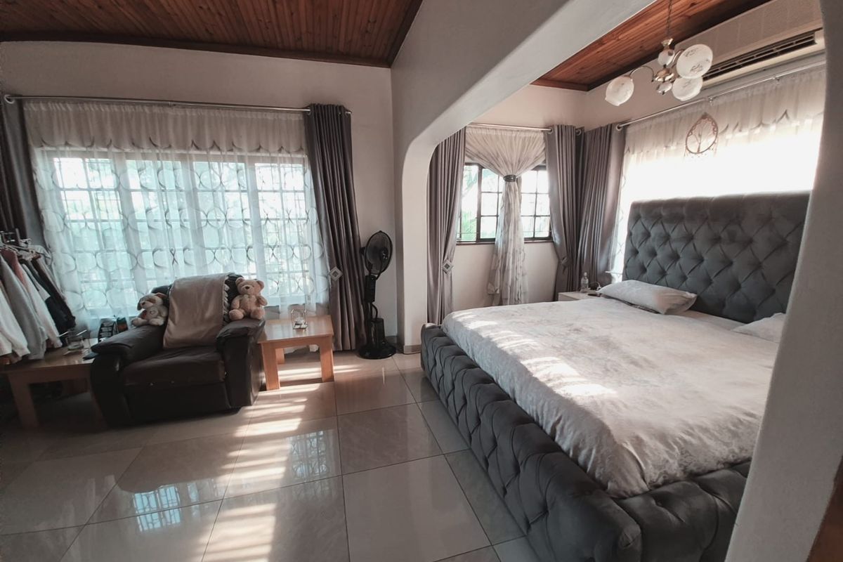 Spacious bedroom featuring tiled flooring, a timber-clad ceiling, and large windows allowing for ample natural light.