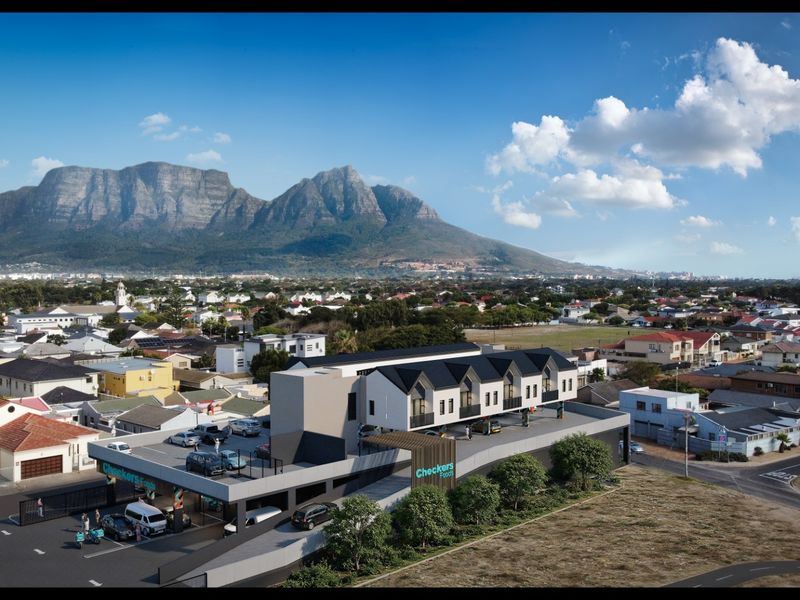 Aerial view of a modern apartment complex featuring integrated retail space and rooftop parking, set against a scenic mountain backdrop.