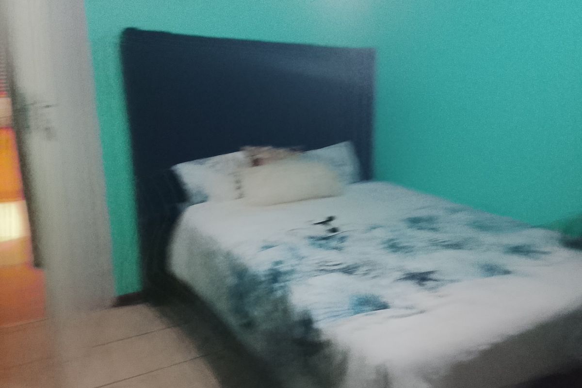 A bedroom featuring tiled flooring and painted walls.