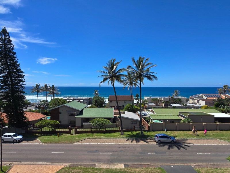 A panoramic elevated view overlooking the coastal neighborhood, street, and the ocean horizon.