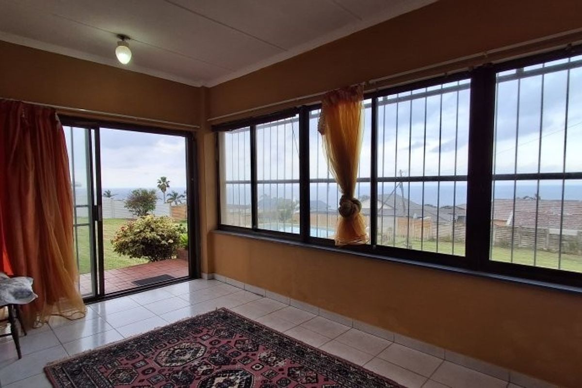 Sunroom featuring large windows with security bars, tiled flooring, and sliding door access to the garden and pool area.