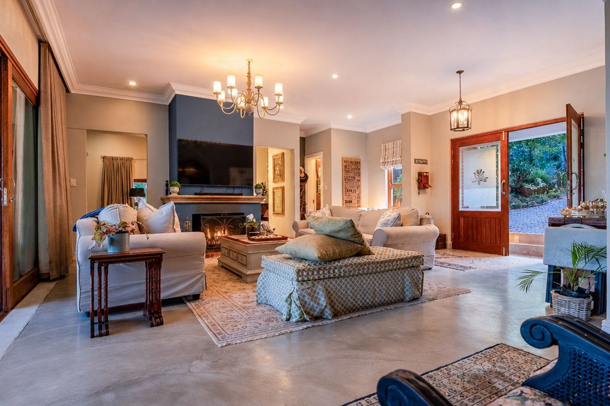 Spacious living room featuring polished concrete floors, a central fireplace, and large sliding glass doors providing seamless access to the outdoor area.