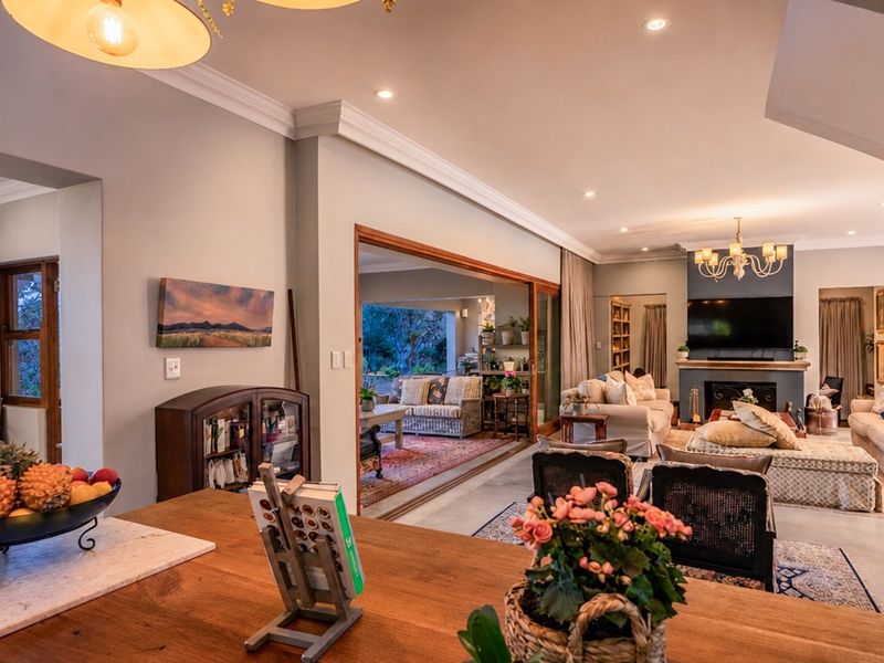 Spacious open-plan living area featuring a fireplace, crown molding, recessed lighting, and large sliding glass doors leading to an outdoor patio space.