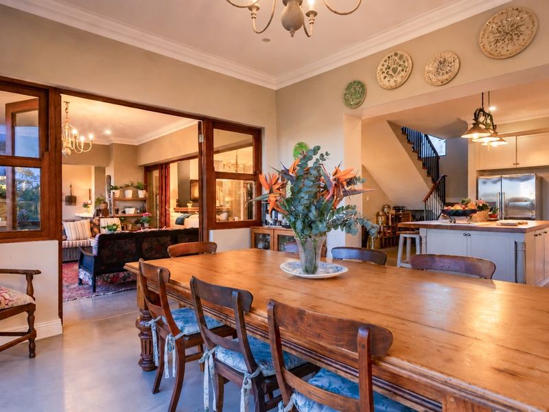 Spacious open-plan dining area flowing into a well-appointed kitchen and adjacent living space, featuring classic timber accents and elegant architectural detailing.