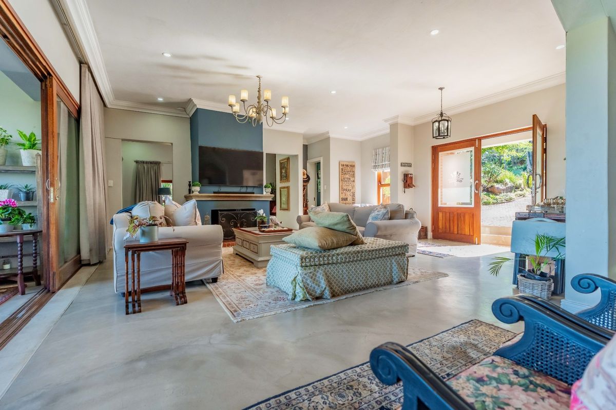 Spacious living room featuring polished concrete floors, a central fireplace, and large sliding glass doors providing seamless access to the outdoor area.