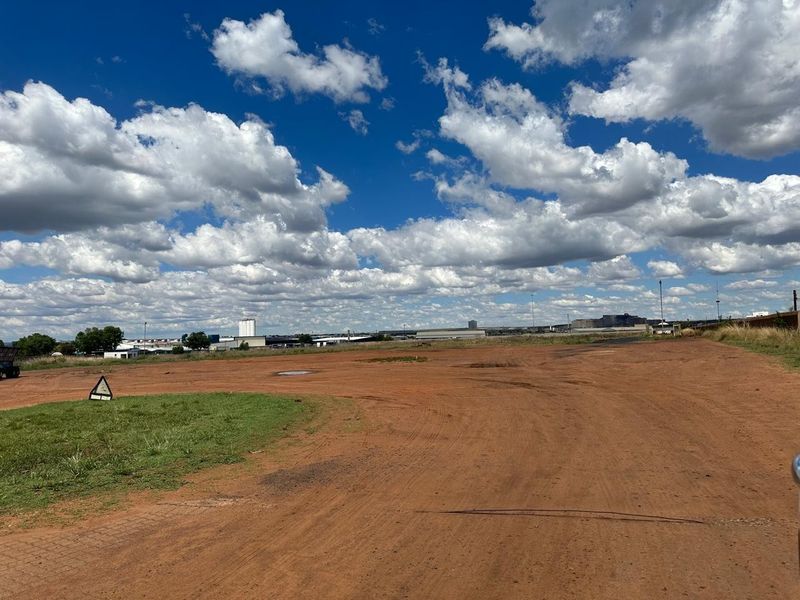 Expansive industrial land plot featuring unpaved ground and open space, suitable for development or storage purposes.