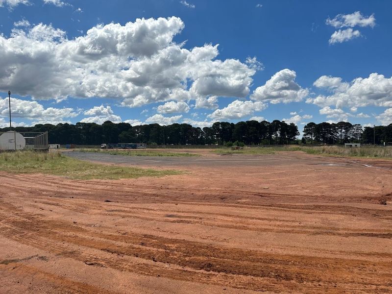 Expansive industrial land plot featuring unpaved ground and open space, suitable for development or heavy vehicle storage.