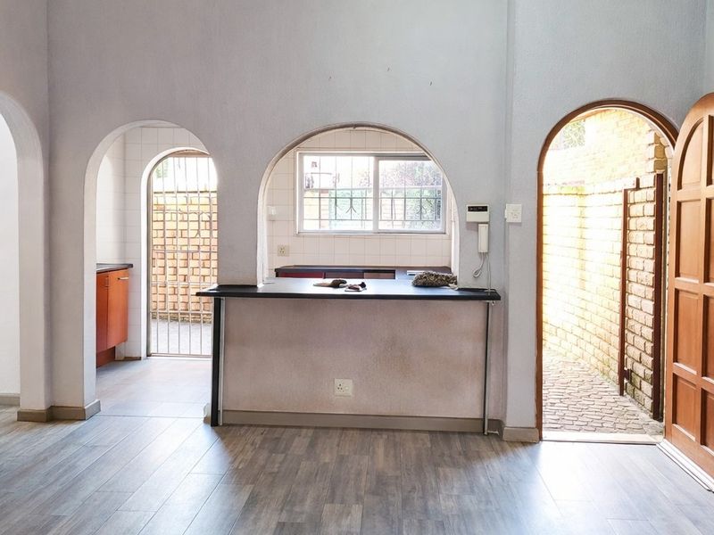 Open plan living area featuring arched doorways, a breakfast bar, and direct access to an exterior courtyard area.