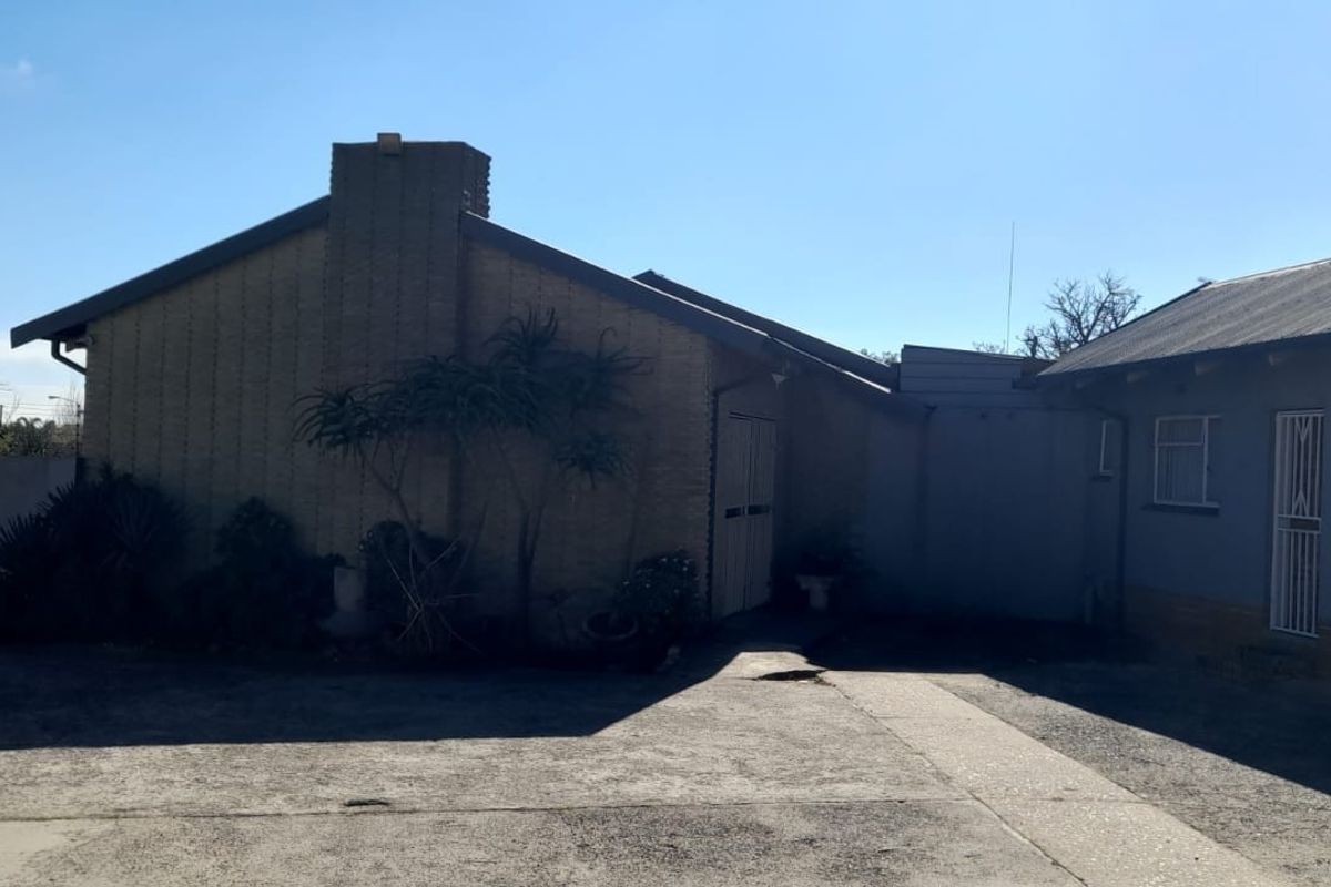 Exterior view of the commercial property showing a brick facade, metal roofing, and paved driveway area.