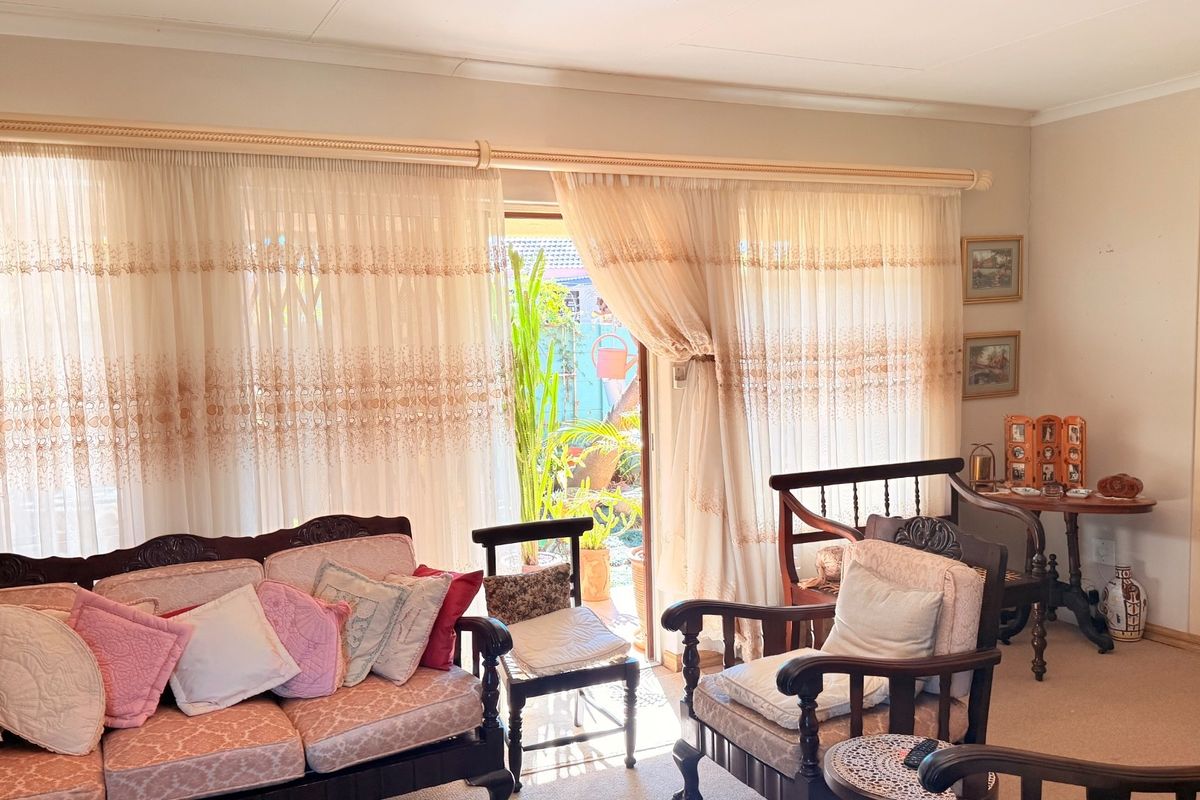 A living room featuring built-in shelving and large sliding glass doors that provide access to the outdoor patio area.
