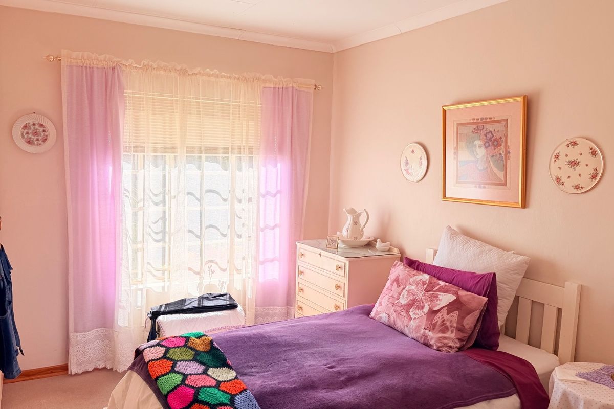 A well-lit bedroom featuring built-in cabinetry and a large window with natural light.