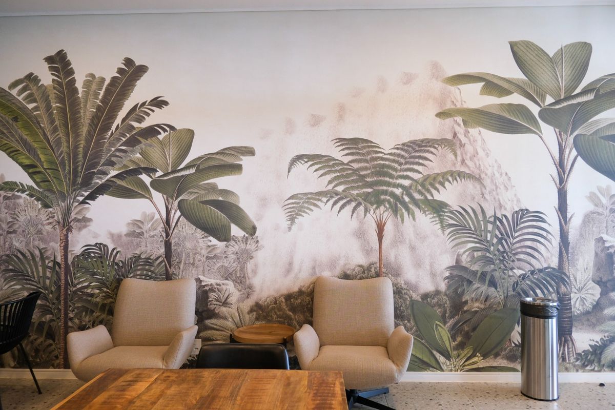 A well-maintained living area featuring a large-scale botanical mural wallpaper and durable terrazzo flooring, creating a bright and modern aesthetic.