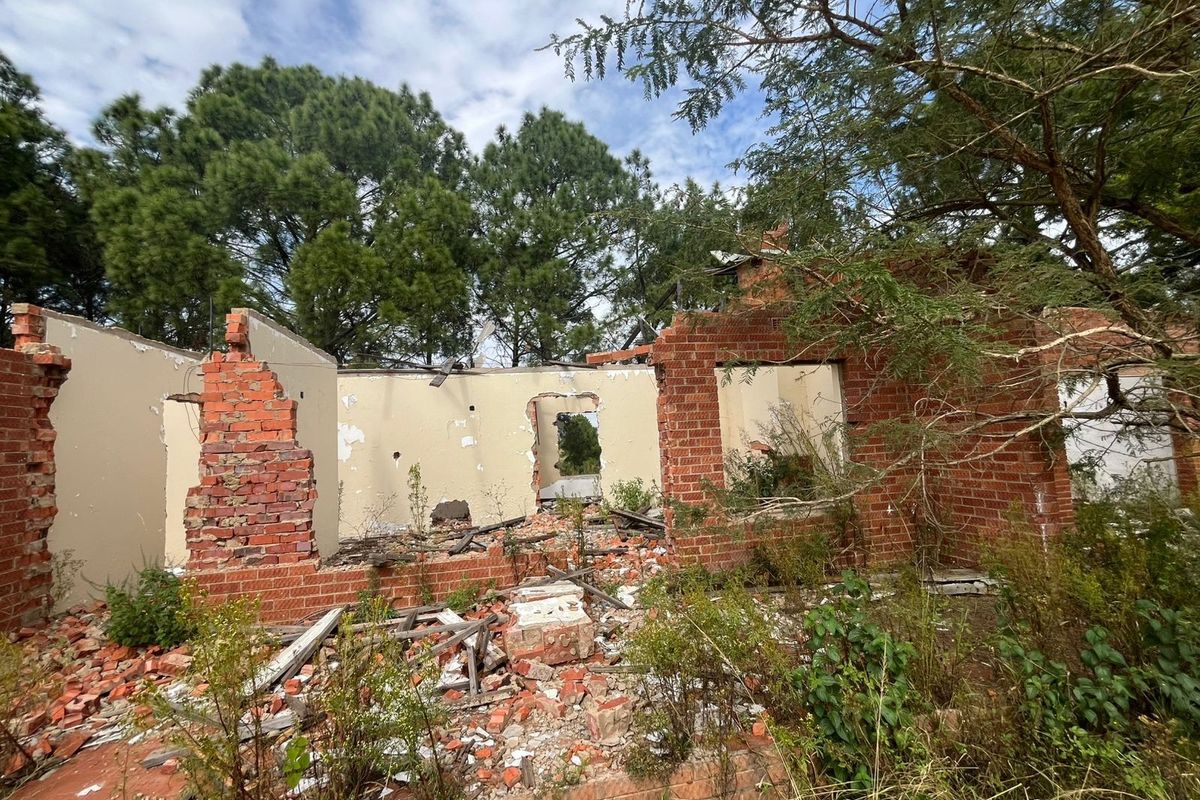 A severely dilapidated structure on the small holding, showing significant structural damage, collapsed walls, and roof failure, requiring complete demolition or major reconstruction.