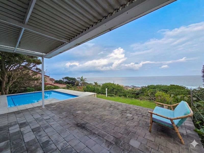 A covered patio area featuring a swimming pool and expansive ocean views, providing an ideal space for outdoor relaxation and entertainment.