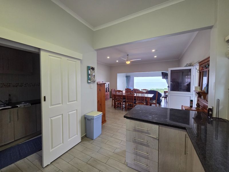 Open-plan living and dining area featuring tiled floors, recessed lighting, and a modern kitchen with granite countertops and built-in cabinetry.